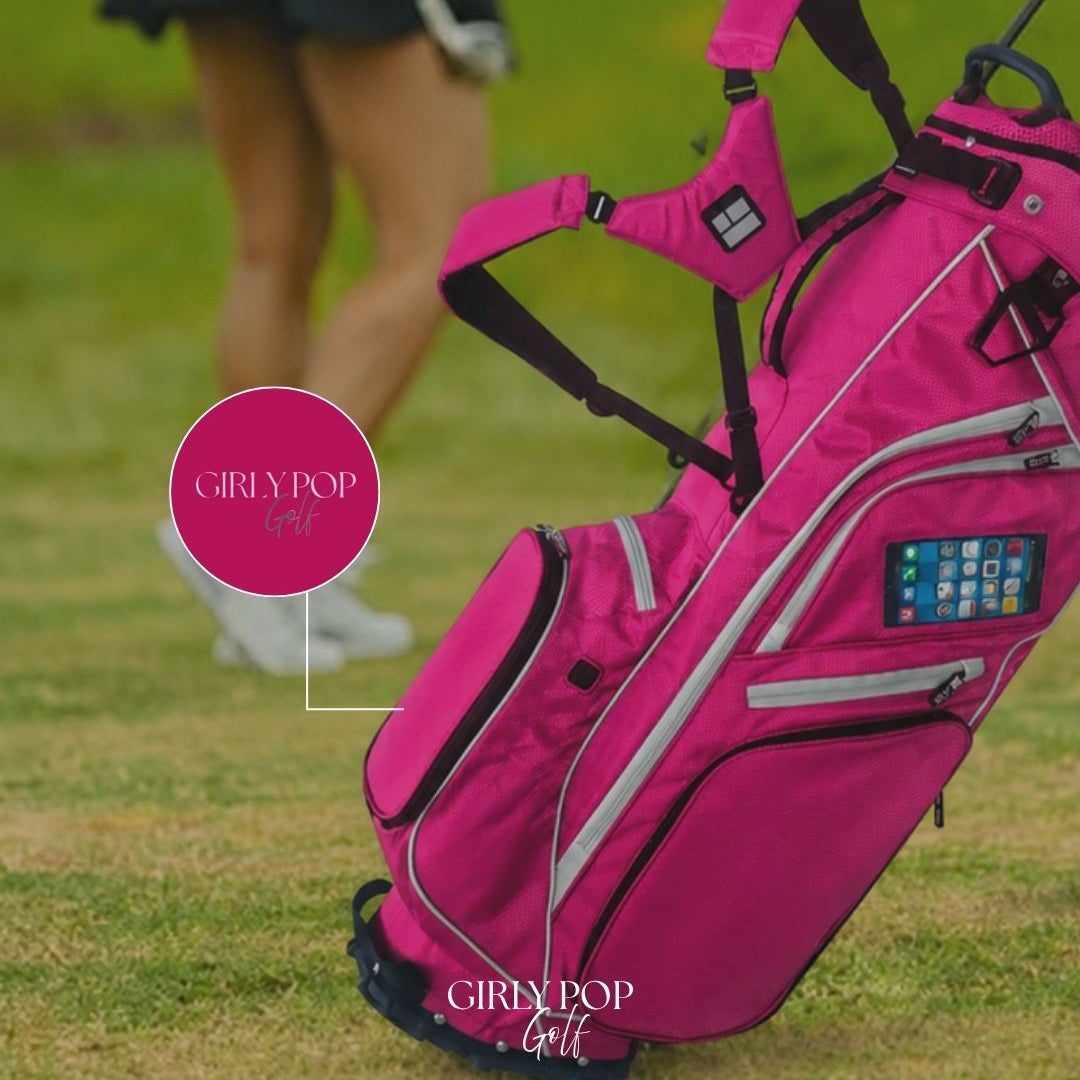 A member walking the fairway behind a hot pink Girly Pop stand bag.